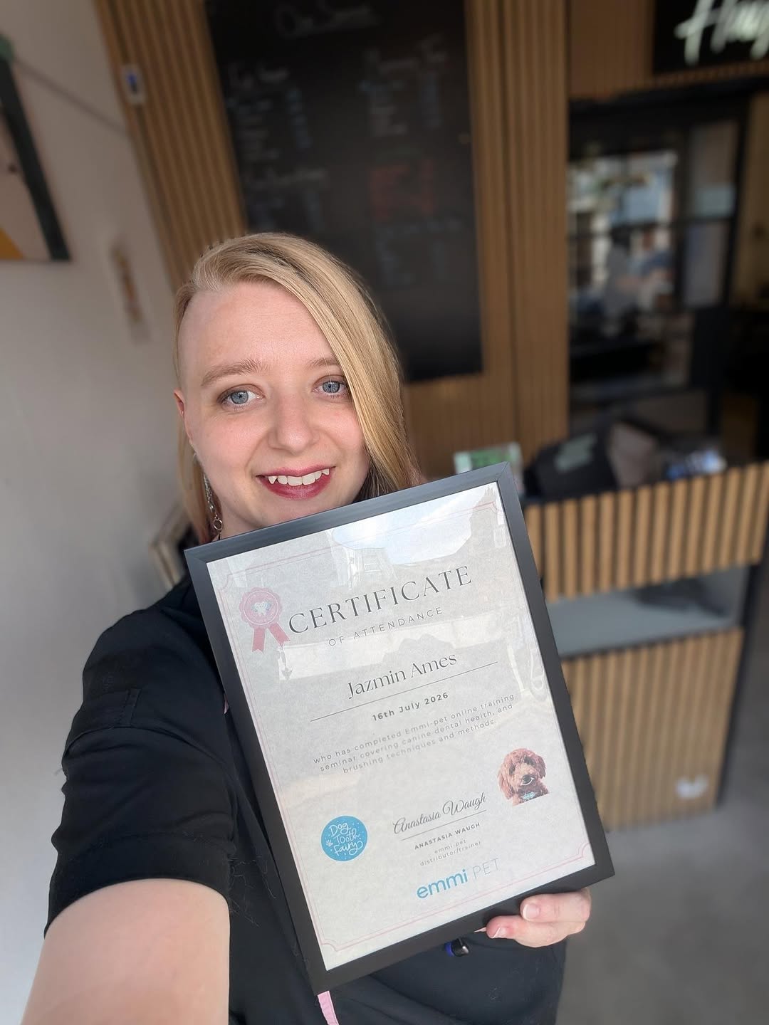 Jazz holding her canine dental training certificate in the salon
